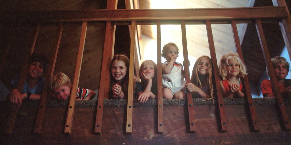 children peeking through railing