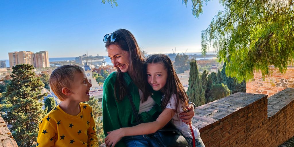 a woman and two children sitting on a bench