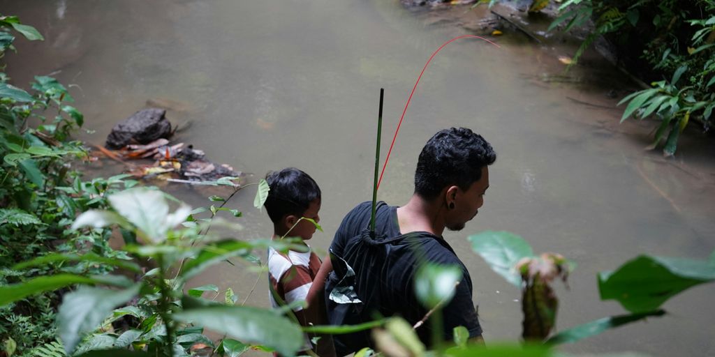 a man and a boy are standing in the water