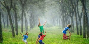 four boy playing ball on green grass